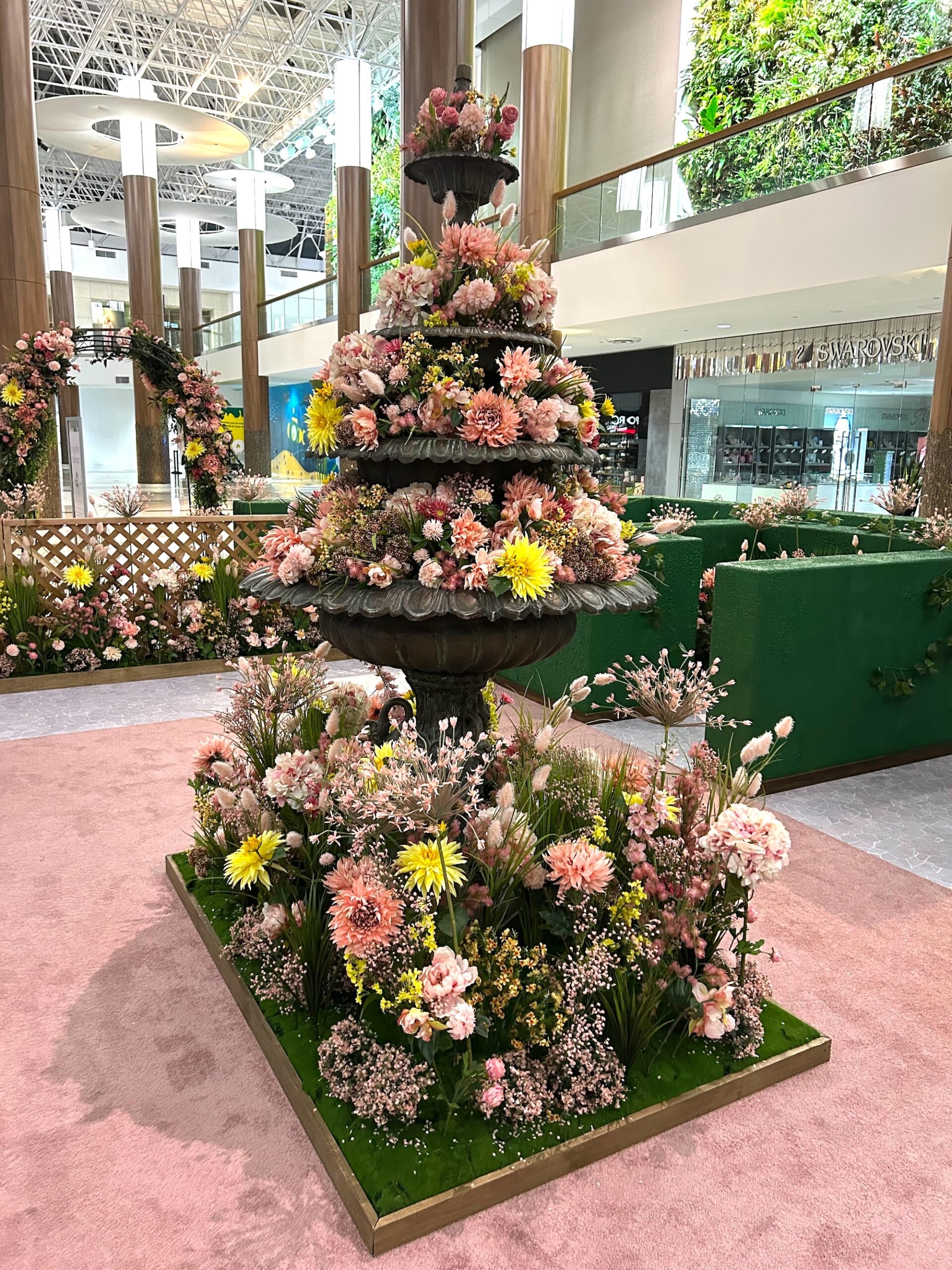 Tiered spring floral centerpiece installation in shopping centre atrium