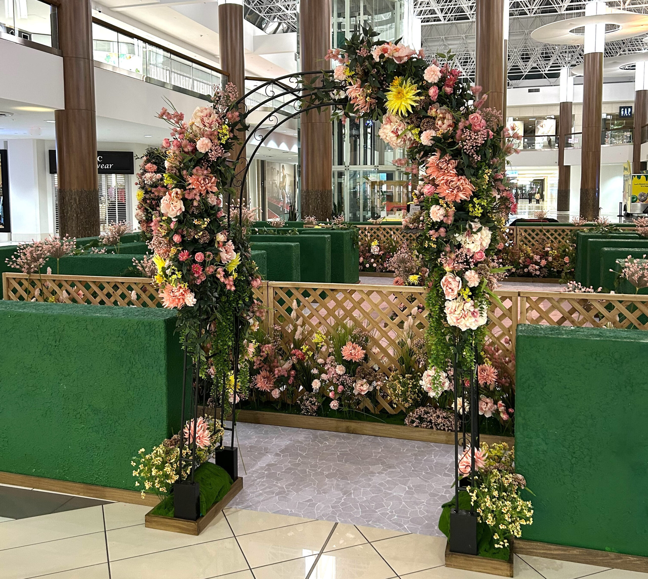 Spring garden display with floral arch in shopping centre atrium