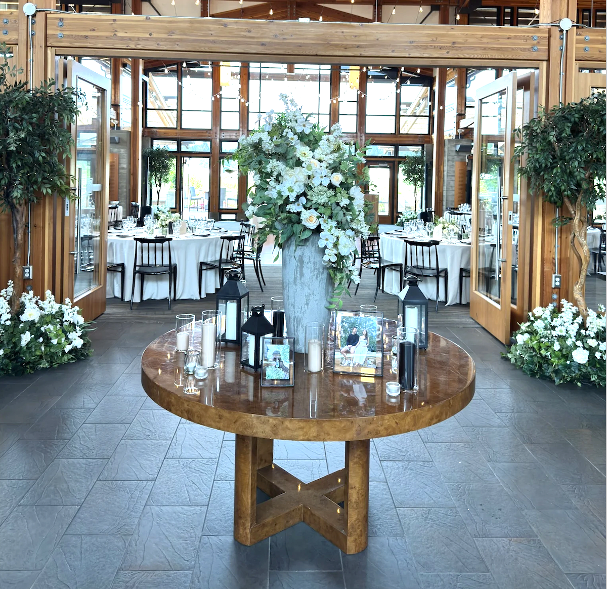 Wedding welcome table with greenery, florals and tree d&eacute;cor