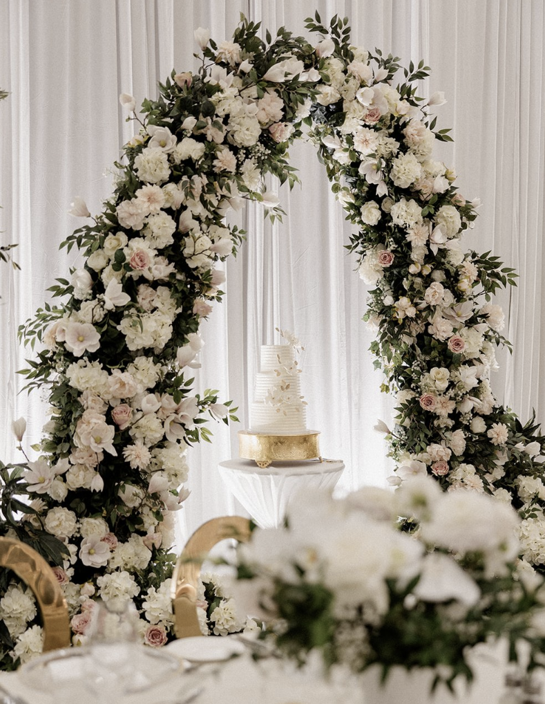 White and blush floral arch for wedding ceremony backdrop