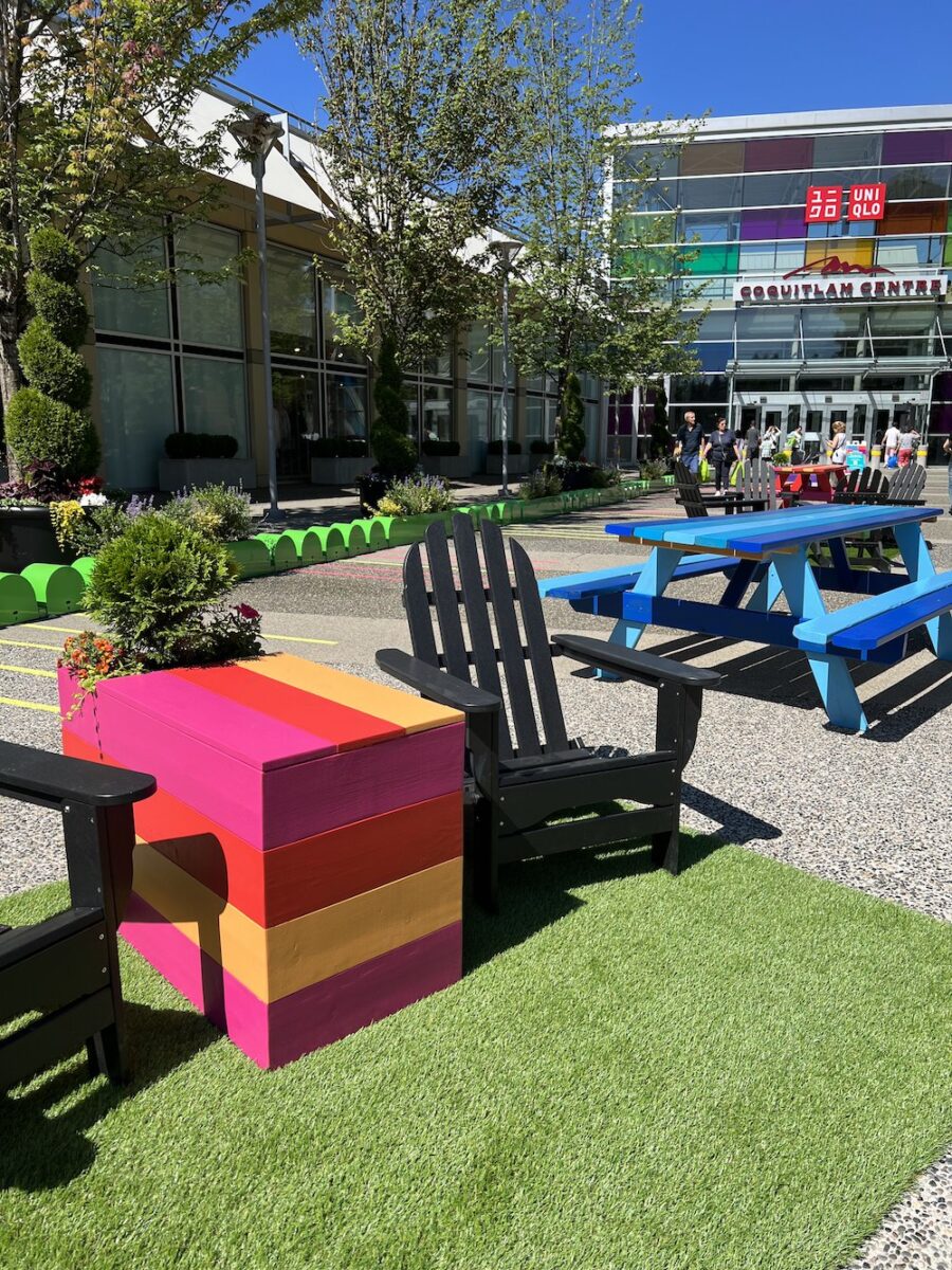 Custom patio furniture and planters on artificial turf in an outdoor shopping centre activation space