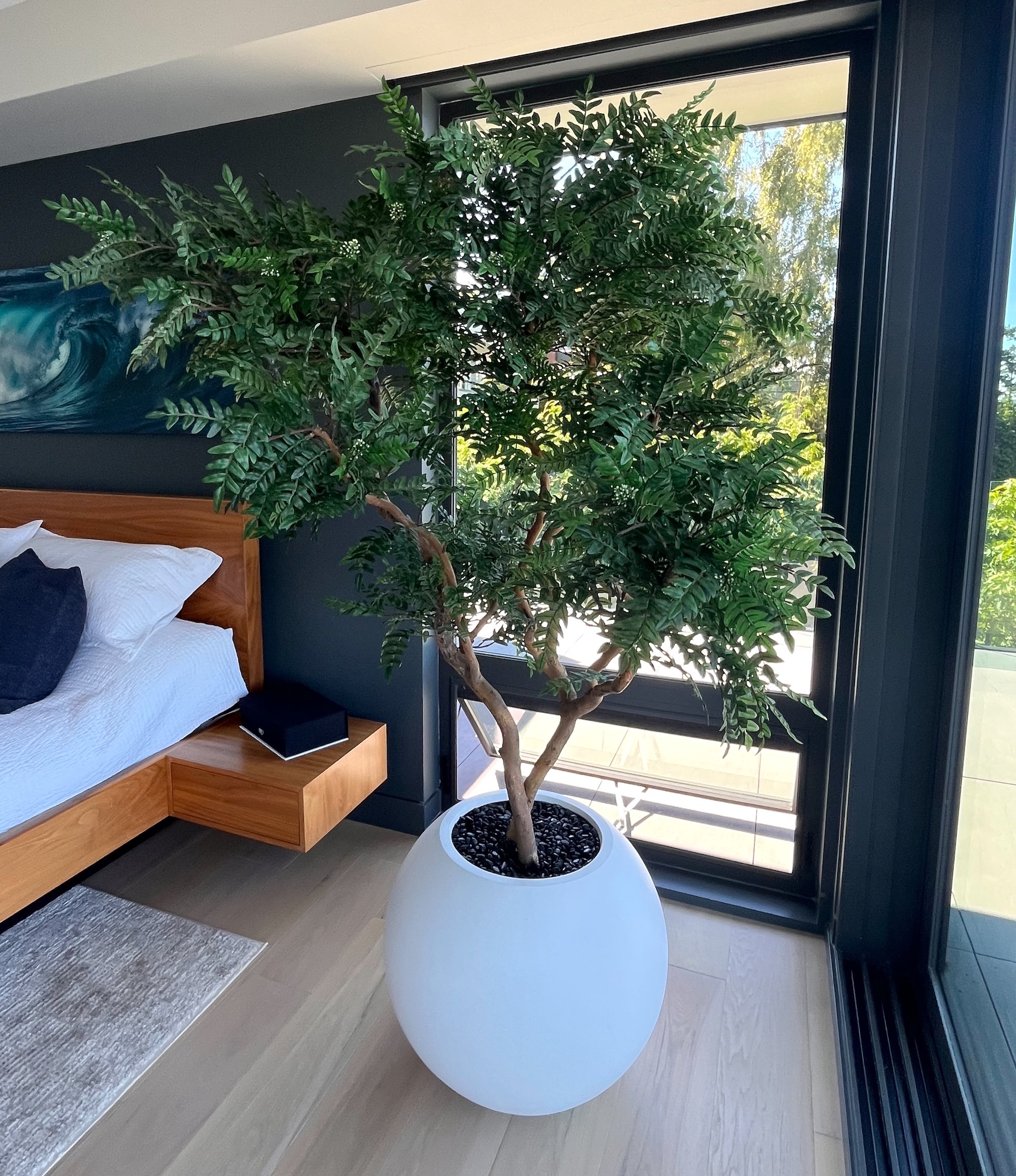 Artificial acacia tree in white planter inside residential interior