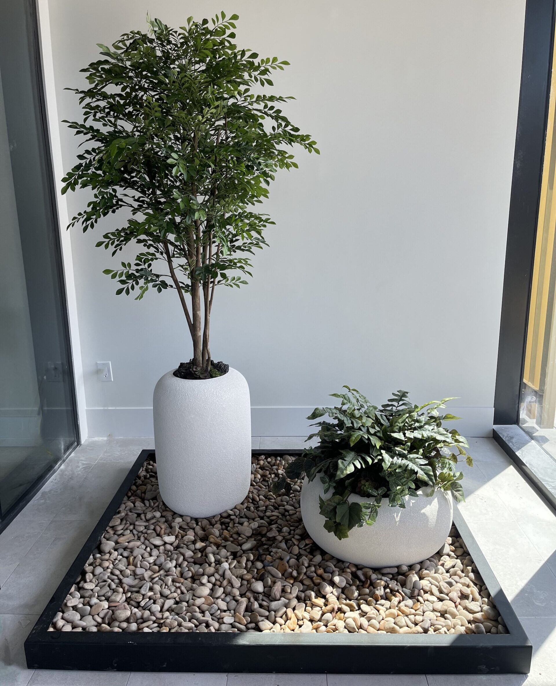 Artificial olive tree in white planter indoors