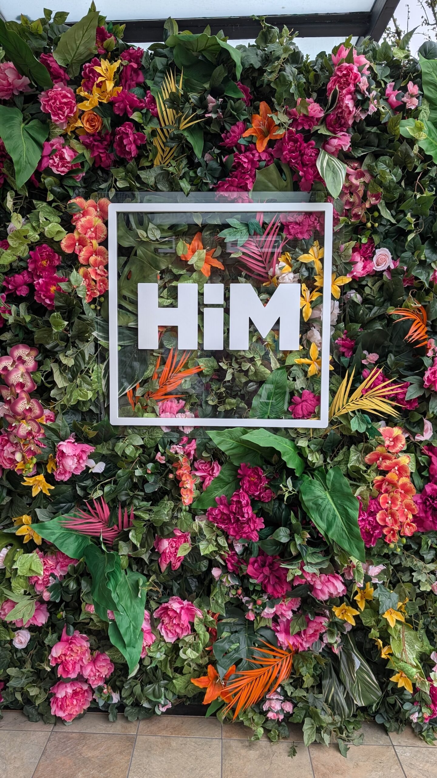 Tropical floral wall with colourful flowers and branded logo display