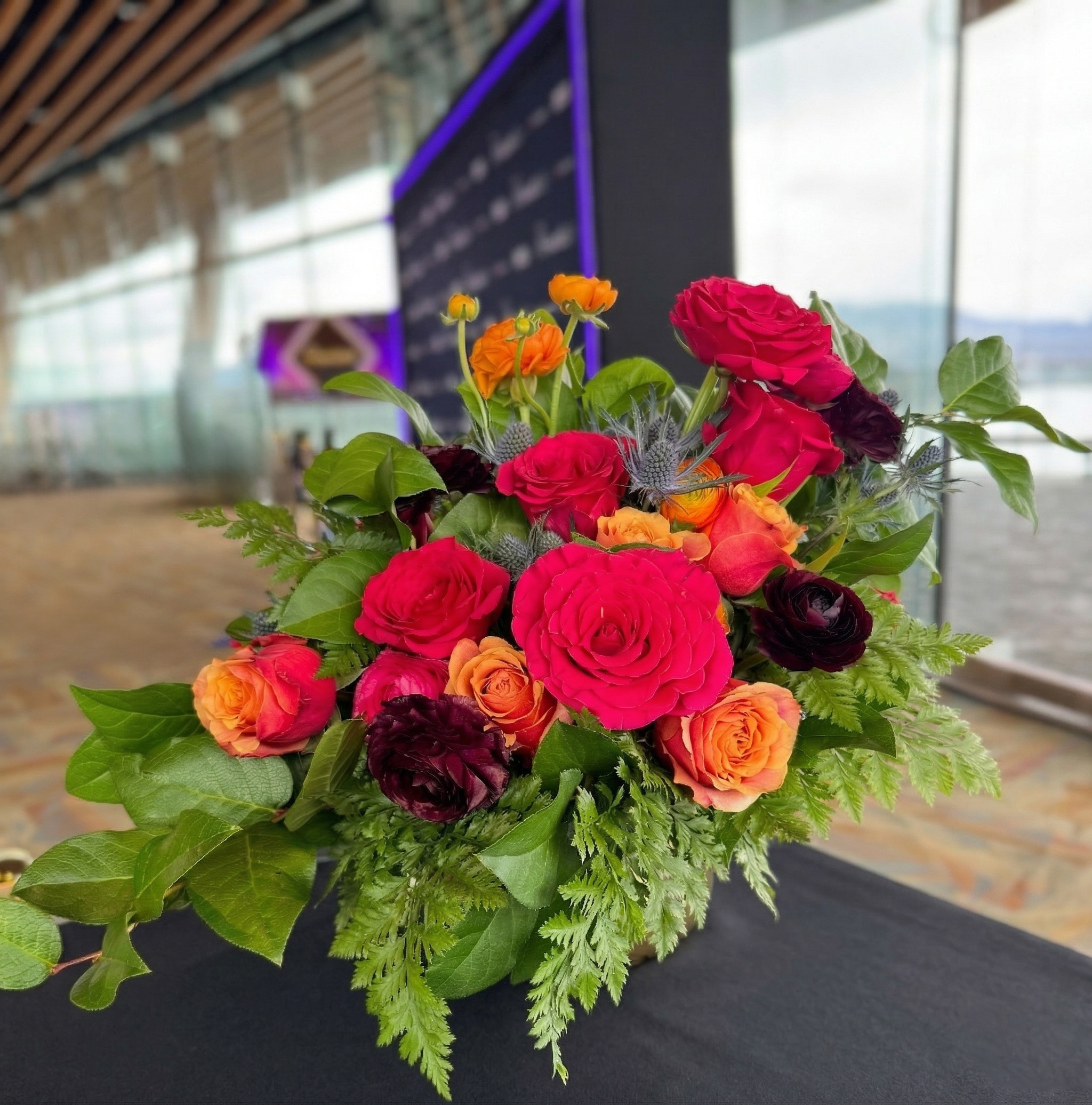 Bright floral centrepiece with mixed colourful flowers on table