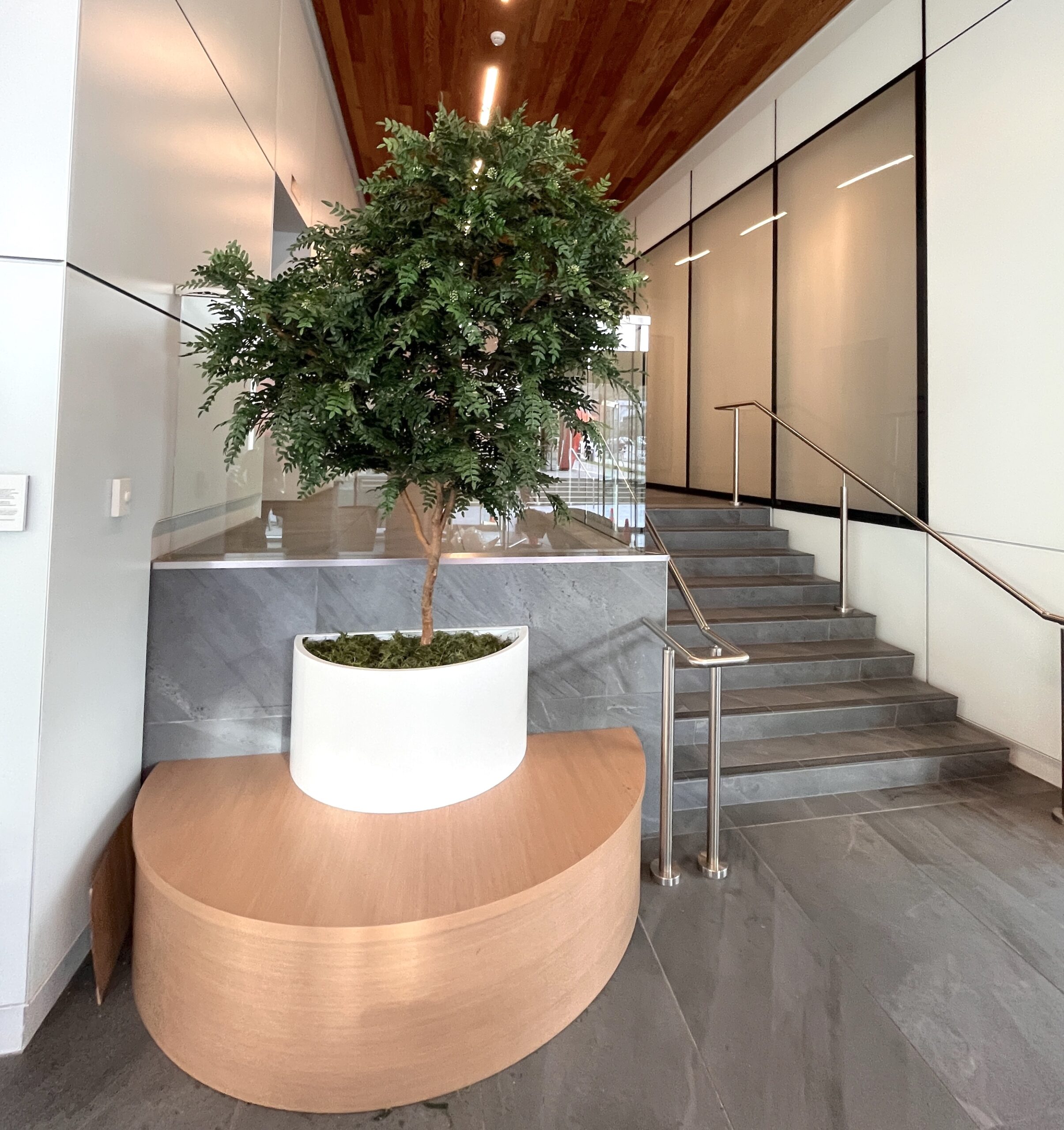 Artificial tree in planter placed in commercial lobby