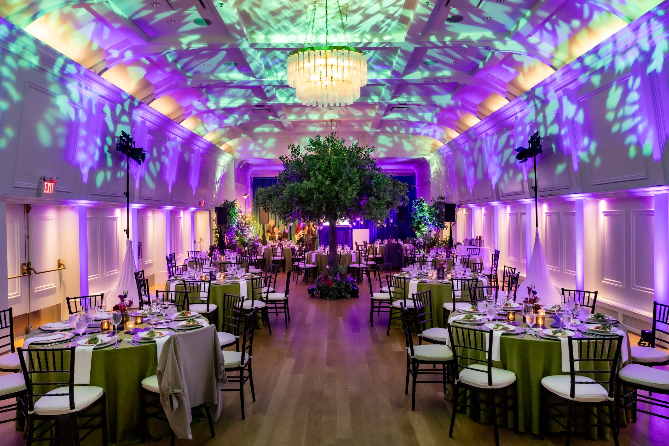 Gala dining room with large faux tree centrepiece and purple lighting