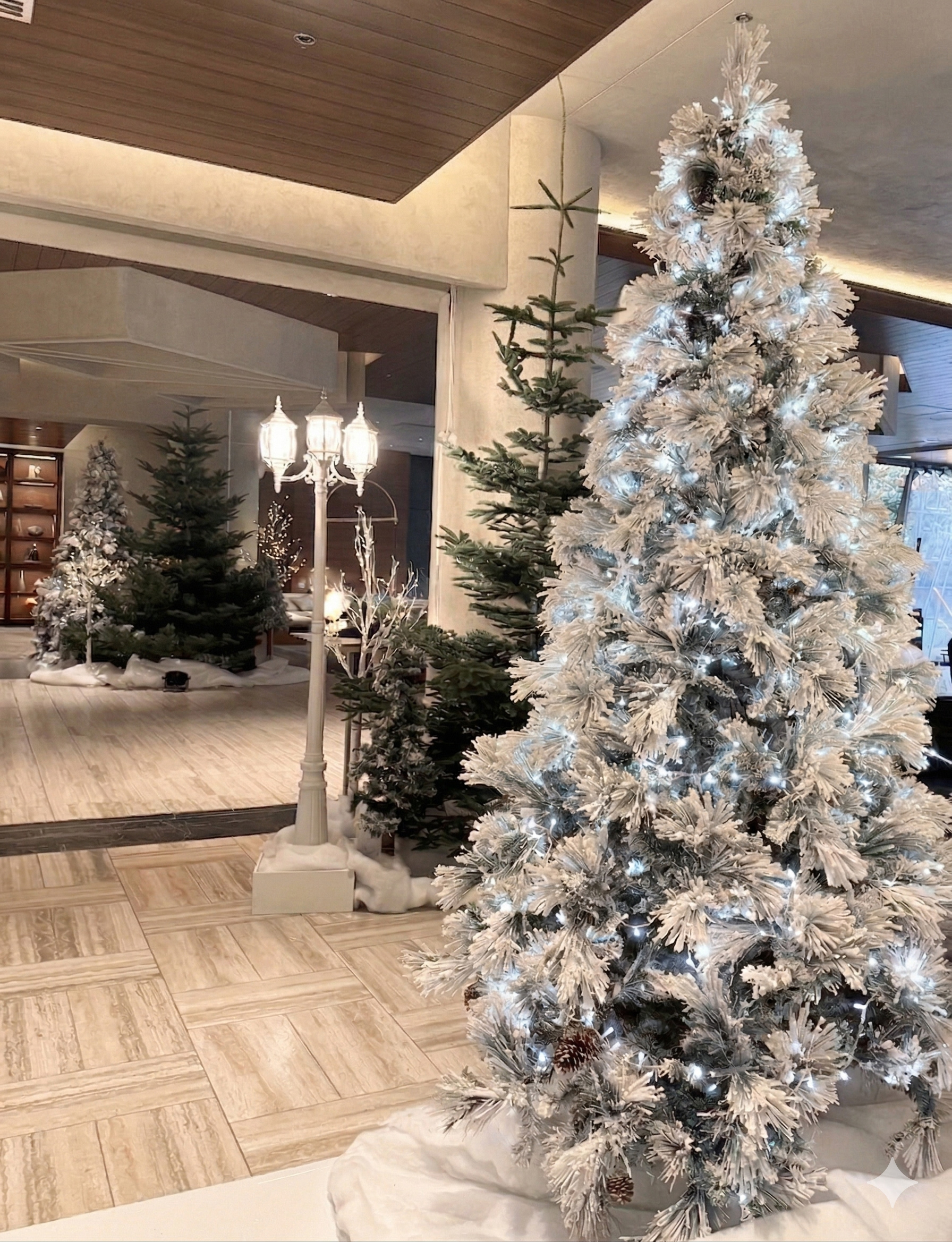 Flocked Christmas tree with white snow effect in indoor event setting