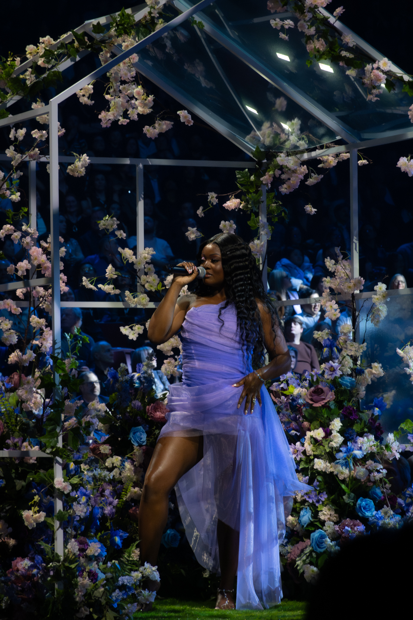 Floral greenhouse stage setup with flowers surrounding live music performance