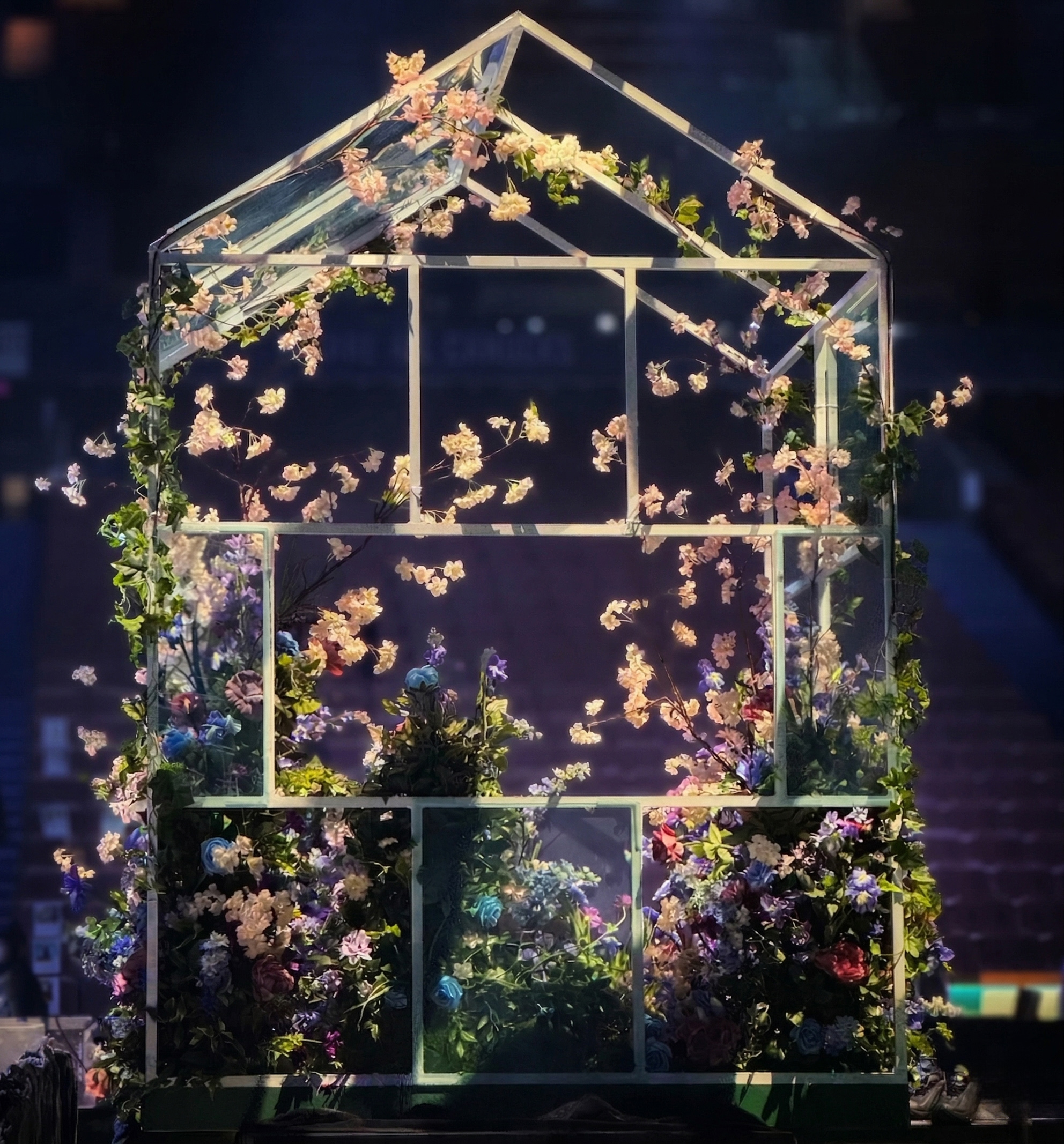 Greenhouse style stage decorated with flowers and greenery