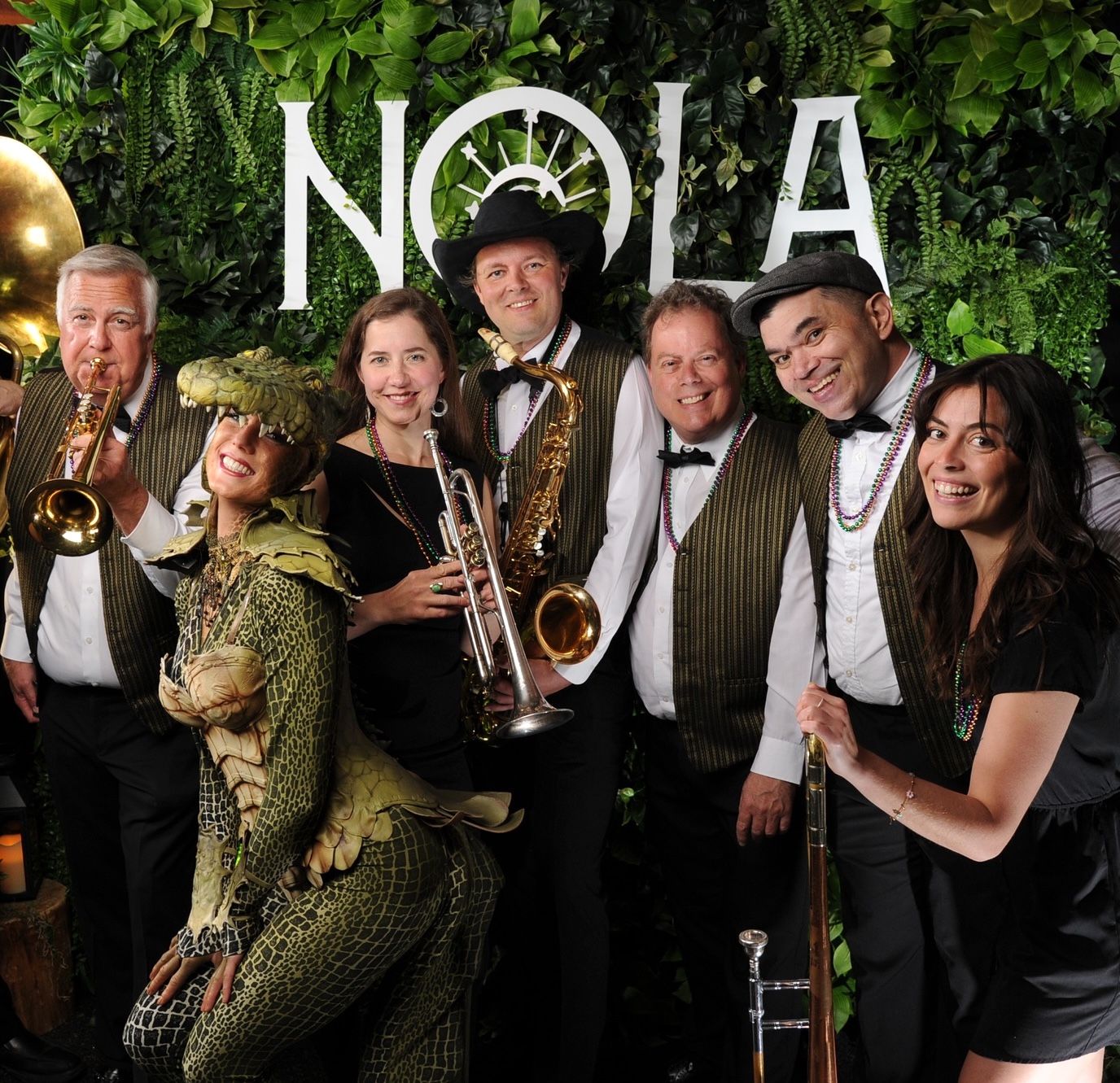 Greenery wall with New Orleans themed signage and live band