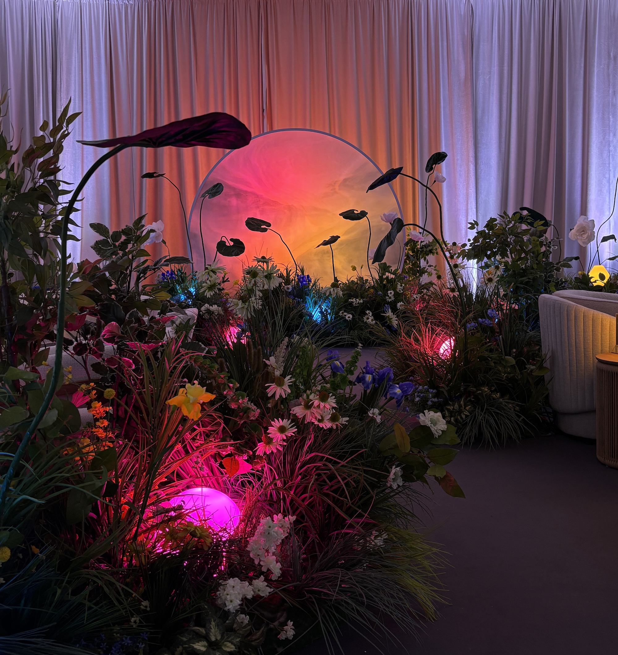 Illuminated garden lounge backdrop with plants and coloured lighting