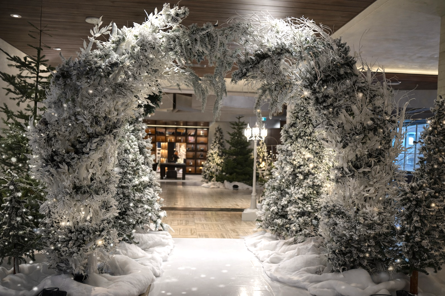 Illuminated winter entry arch with frosted branches and lighting