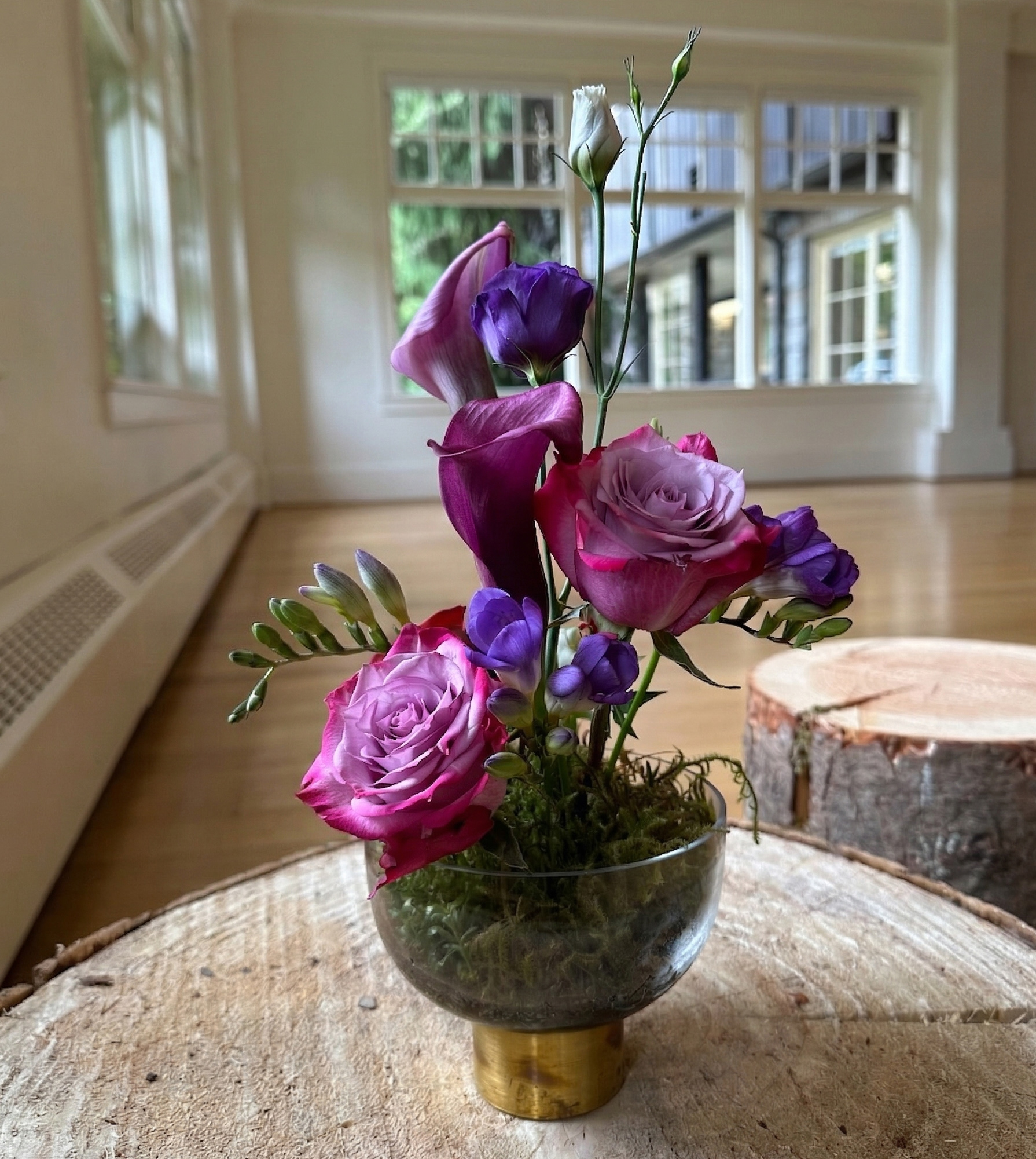 Purple and pink floral centrepiece with roses on table