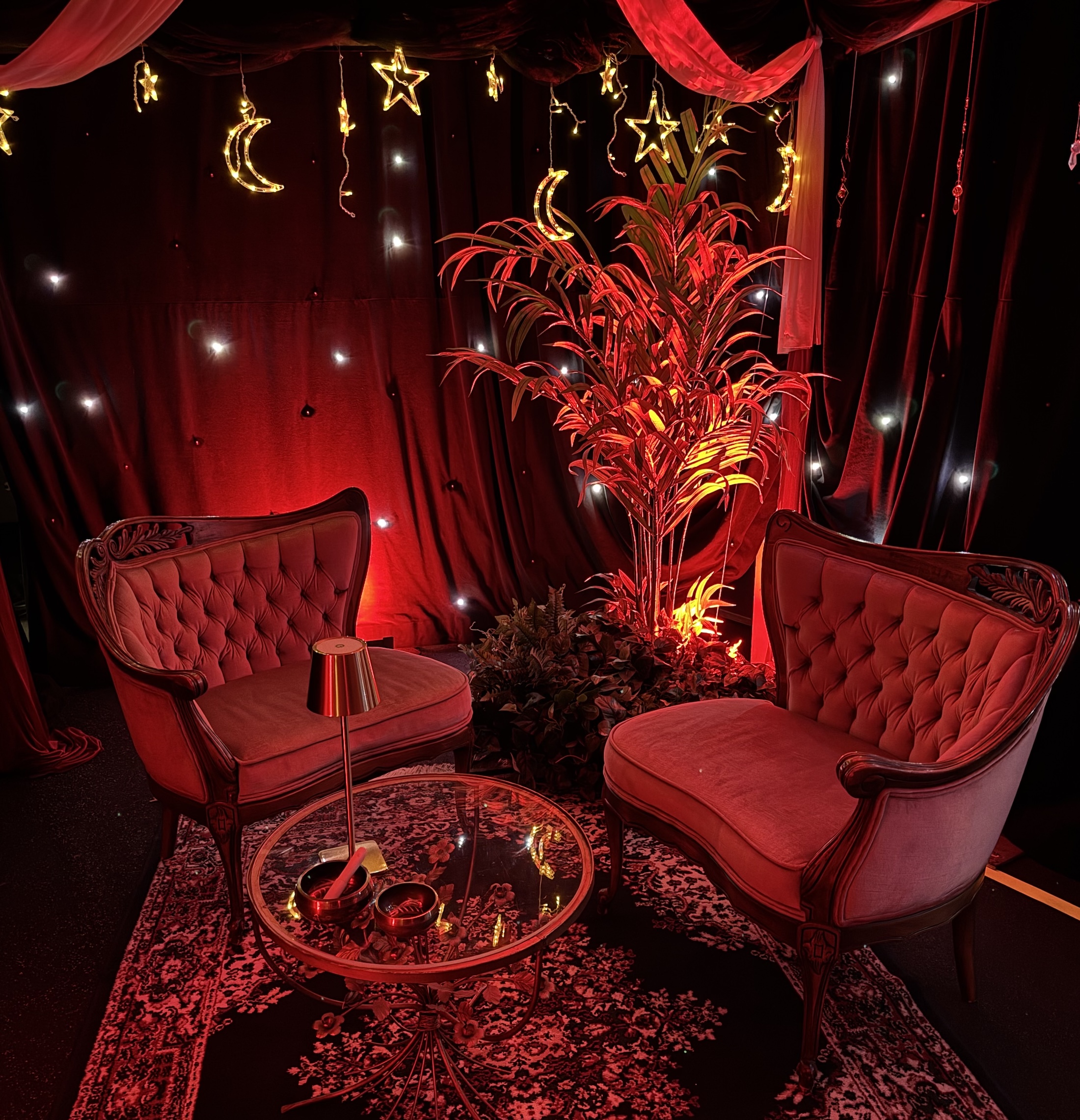 Red lounge seating with illuminated palm tree and draped backdrop