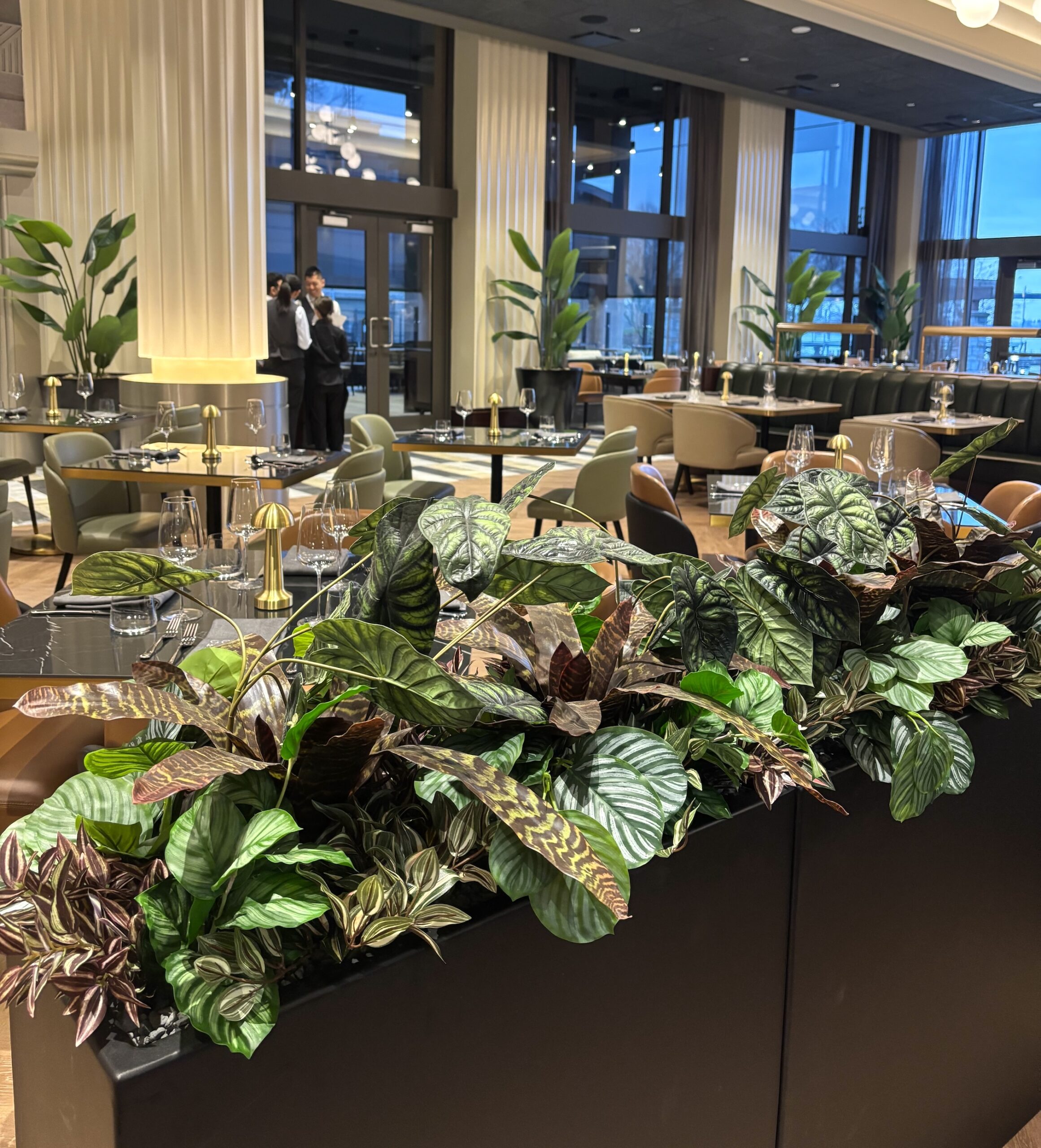 Replica potted plants styled throughout a restaurant seating area