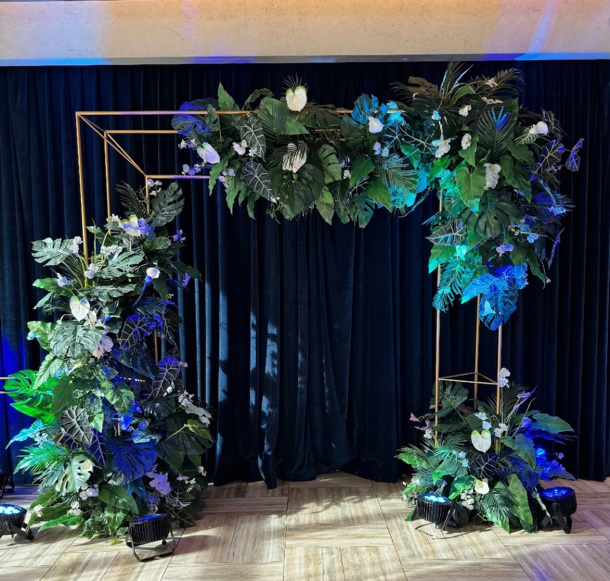 Tropical floral arch backdrop with greenery and flowers for event