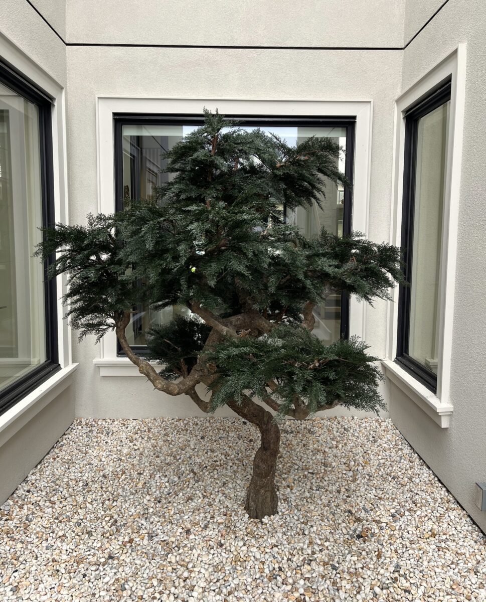 UV-inherent artificial bonsai tree in a gravel courtyard