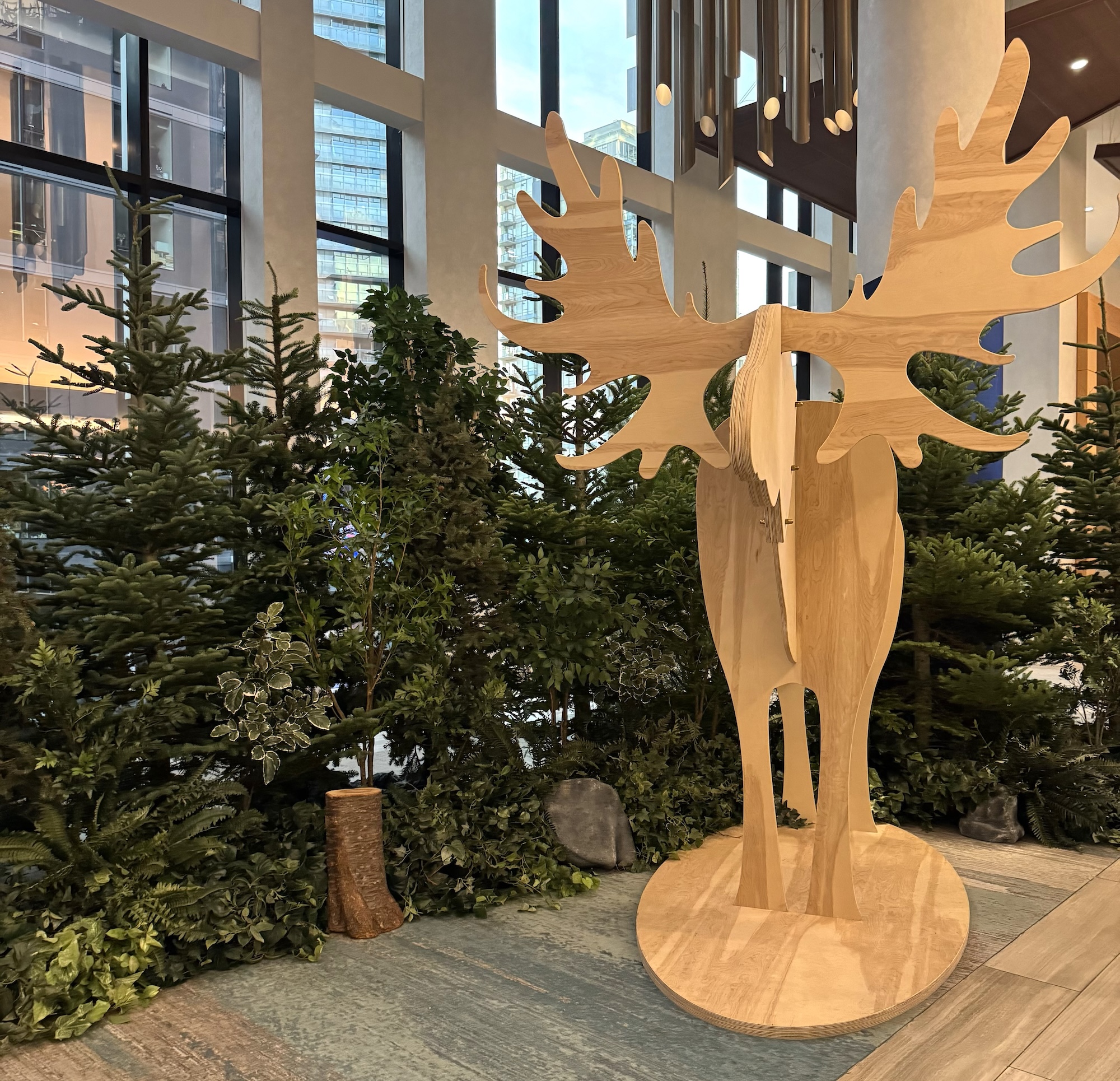 Wooden moose feature with live evergreen trees in corporate event space